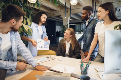 Team of diverse coworkers in modern office discuss their project together Team of diverse coworkers in modern office discuss their project together